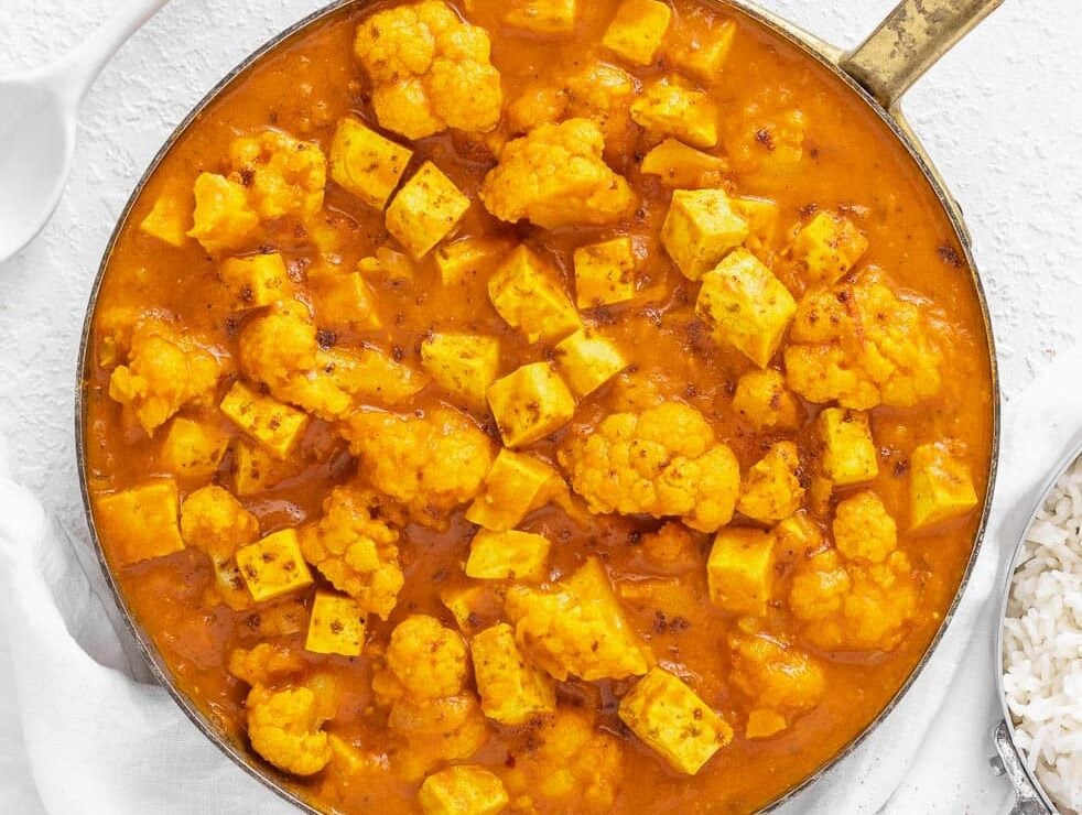 Tofu curry with cauliflower in a skillet.