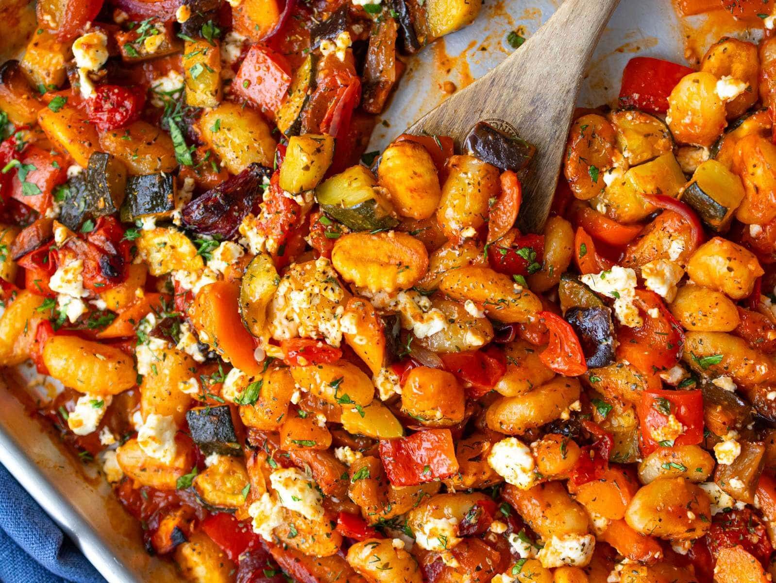 Top down Greek sheet pan gnocchi dinner with colorful roasted Mediterranean vegetables.