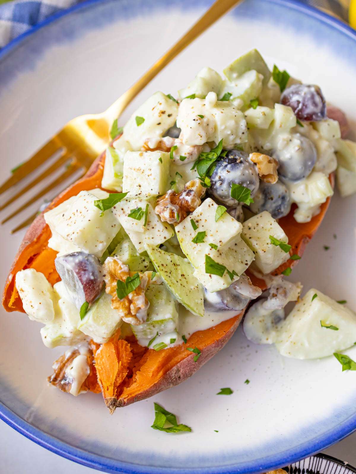 Waldorf salad with apples celery grapes and toasted walnuts served on a baked sweet potato.