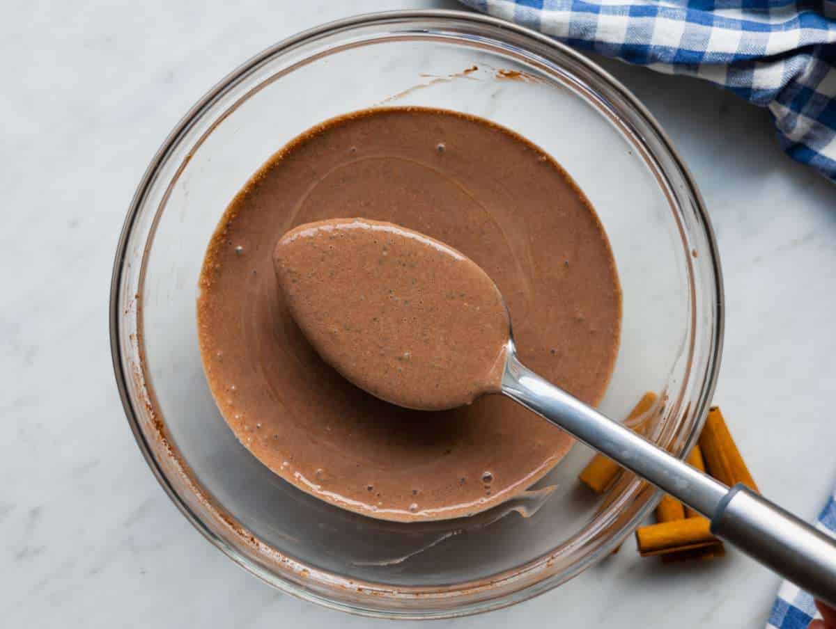 Whisking chia seeds into chocolate yogurt mixture to thicken evenly without clumps.