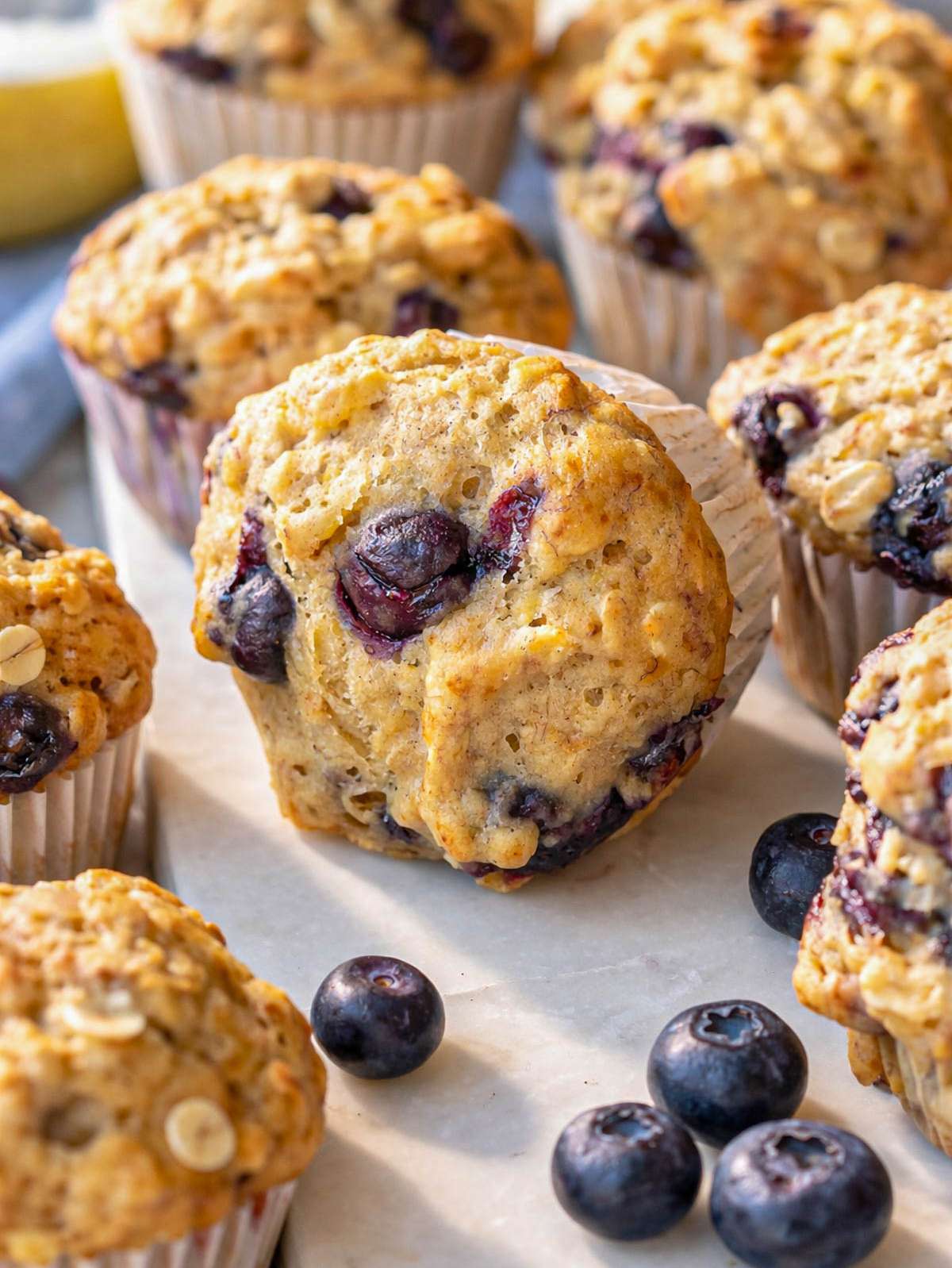 Baking ingredients arranged on a counter with bananas blueberries oats yogurt and flour.