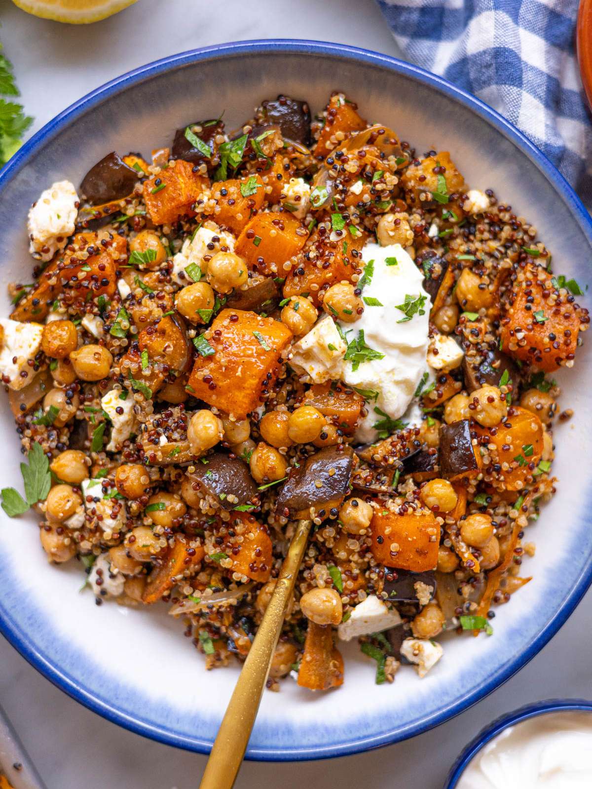 Chickpea shawarma bowl served with quinoa, roasted vegetables, Greek yogurt, and feta in a shallow bowl.