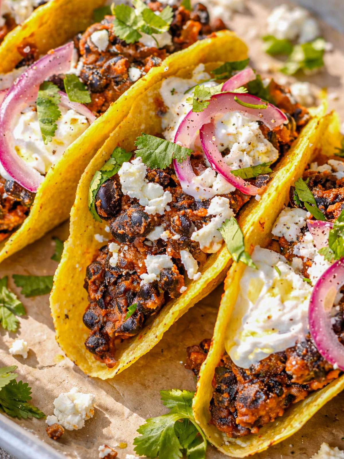 Close up of black bean taco filling showing creamy texture beans spices and melted feta.