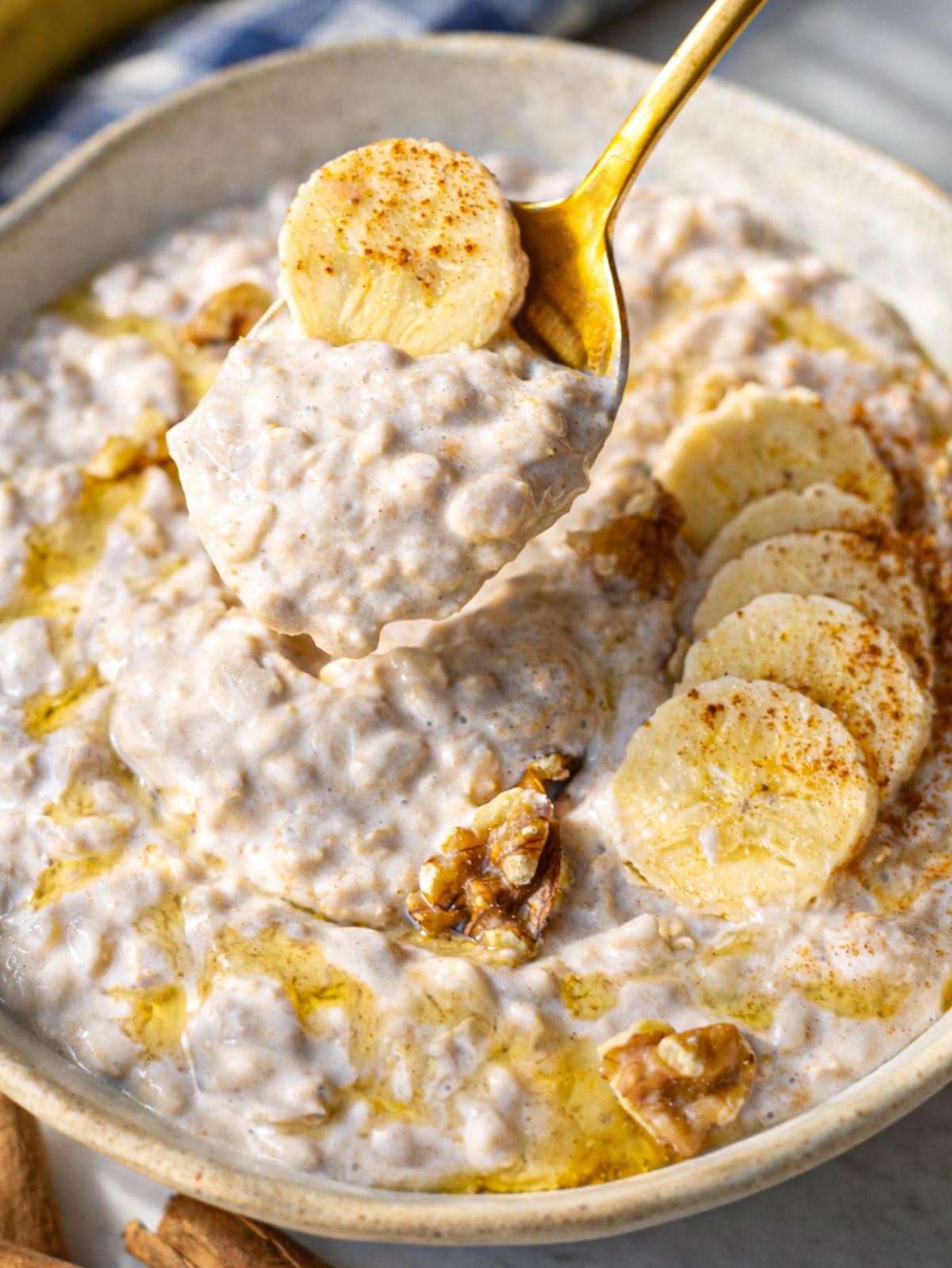 Close-up of creamy oats showing thick texture mashed banana and cinnamon speckles.
