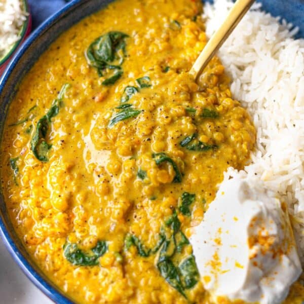 Creamy bowl of easy red lentil dal with basmati rice and yogurt on top.