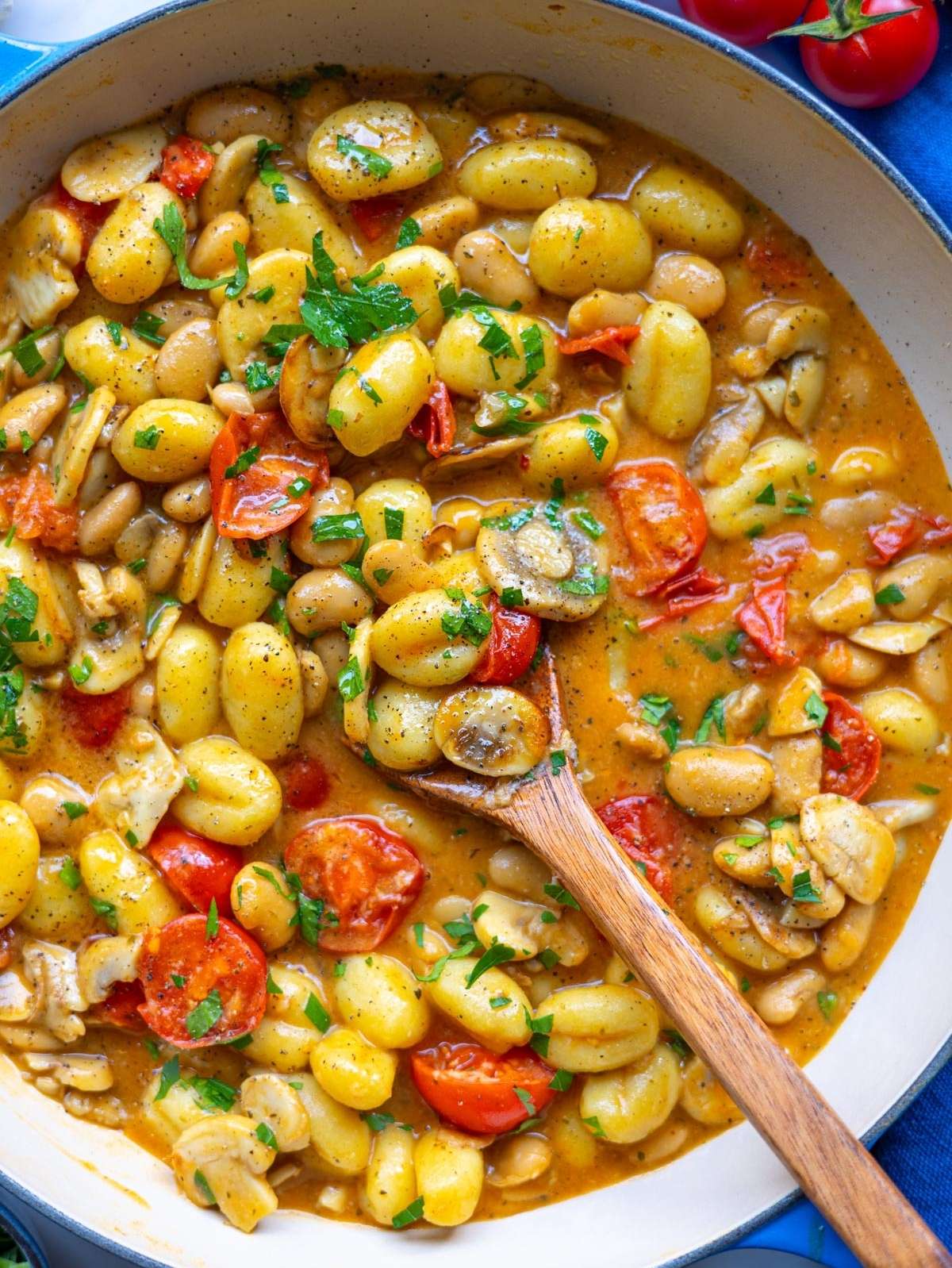 Finished mushroom gnocchi served in a skillet, topped with parmesan and parsley, ready to eat.
