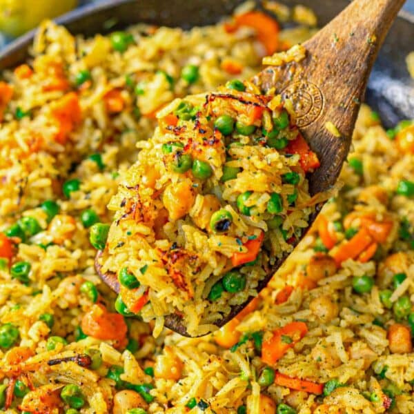 Fragrant vegetable biryani in natural light showing separate grains and vibrant vegetables.