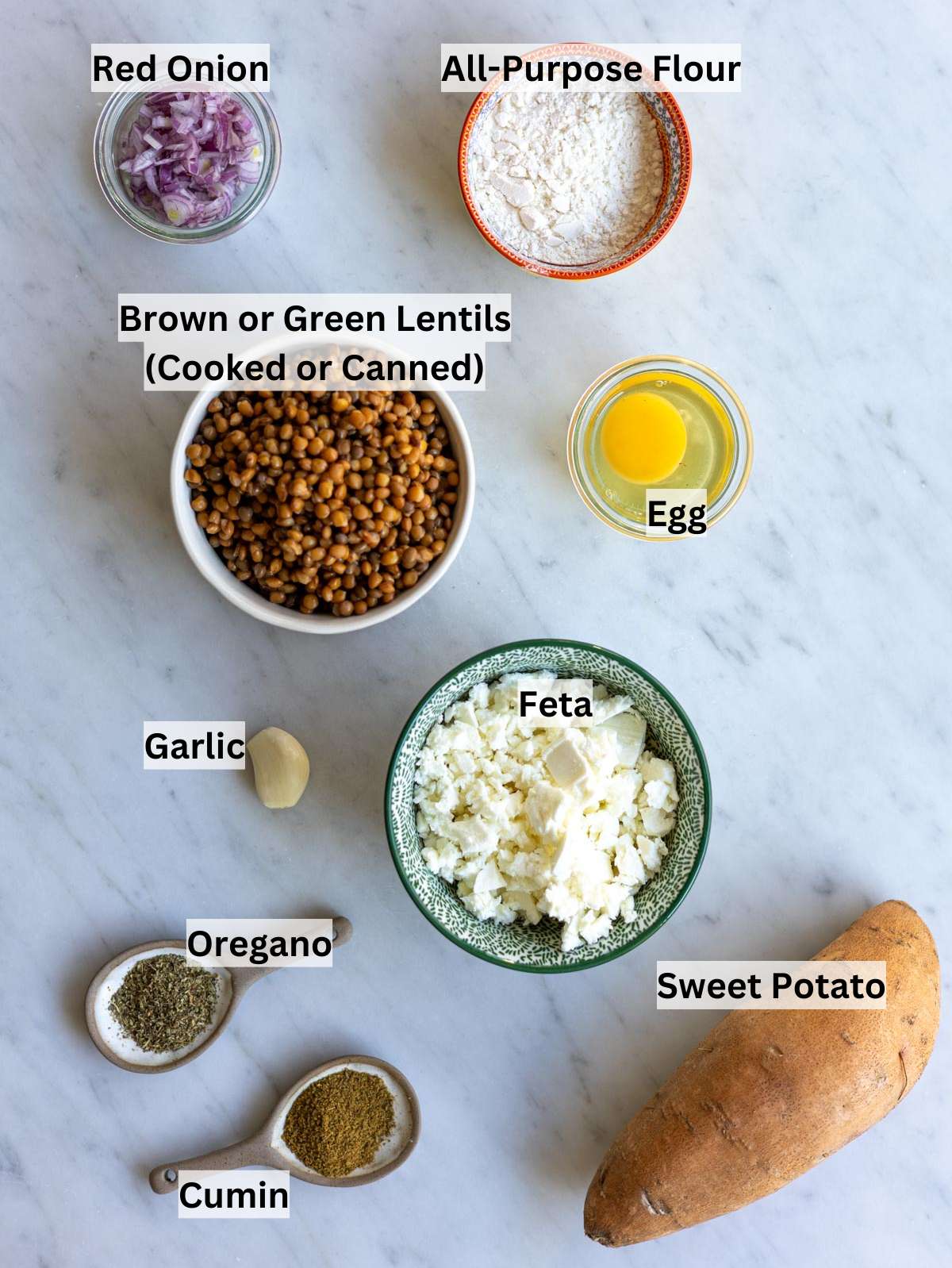 Ingredients arranged on counter including lentils sweet potato feta onion garlic herbs and flour.