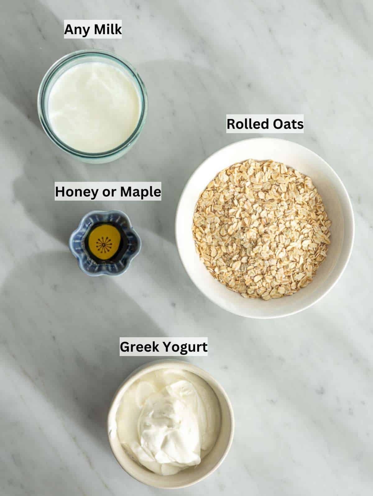 Ingredients for Greek yogurt overnight oats arranged on a marble surface before mixing.