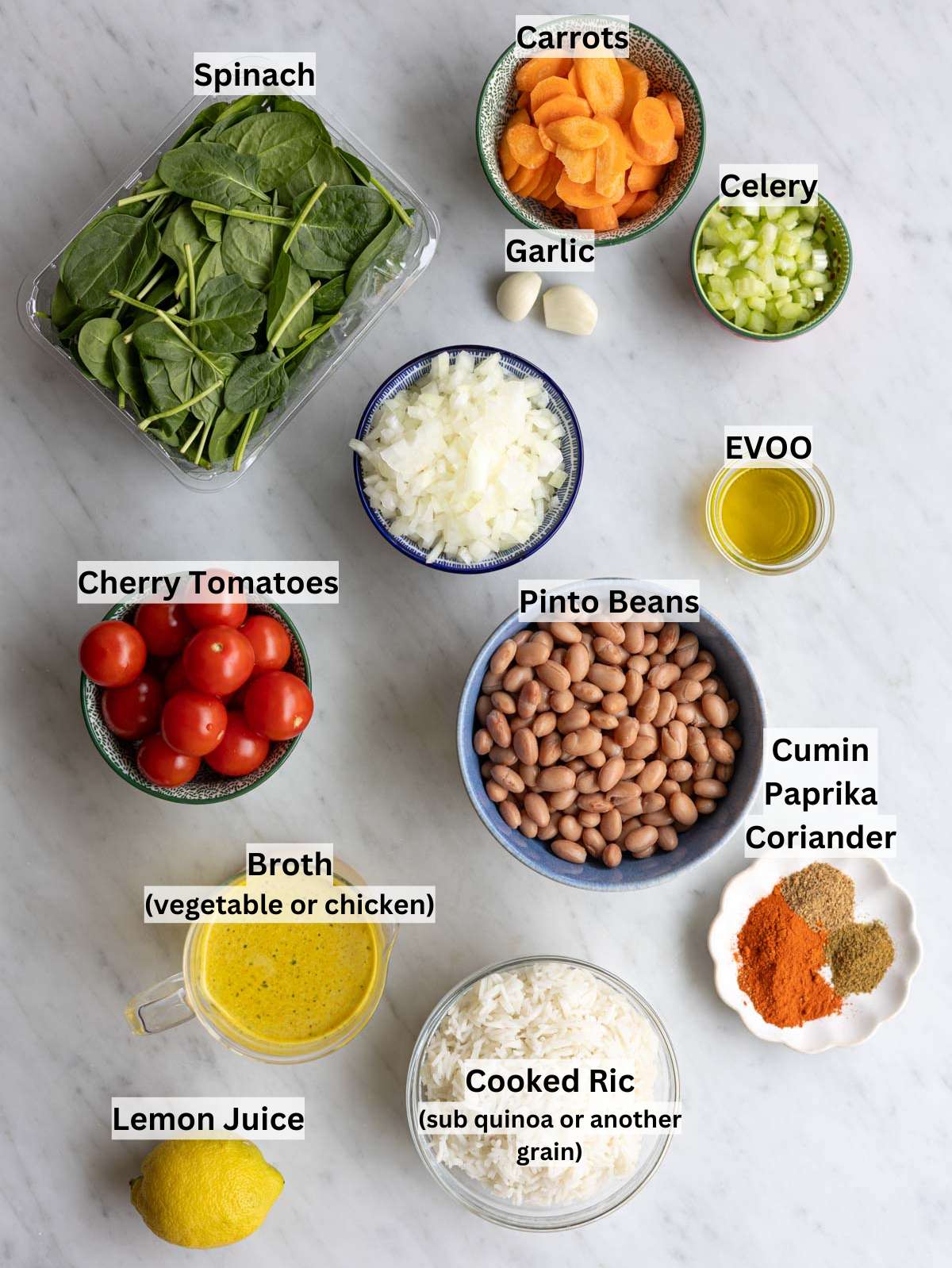 Ingredients for Mediterranean pinto bean soup on a wooden table with beans, vegetables, spices, and olive oil.