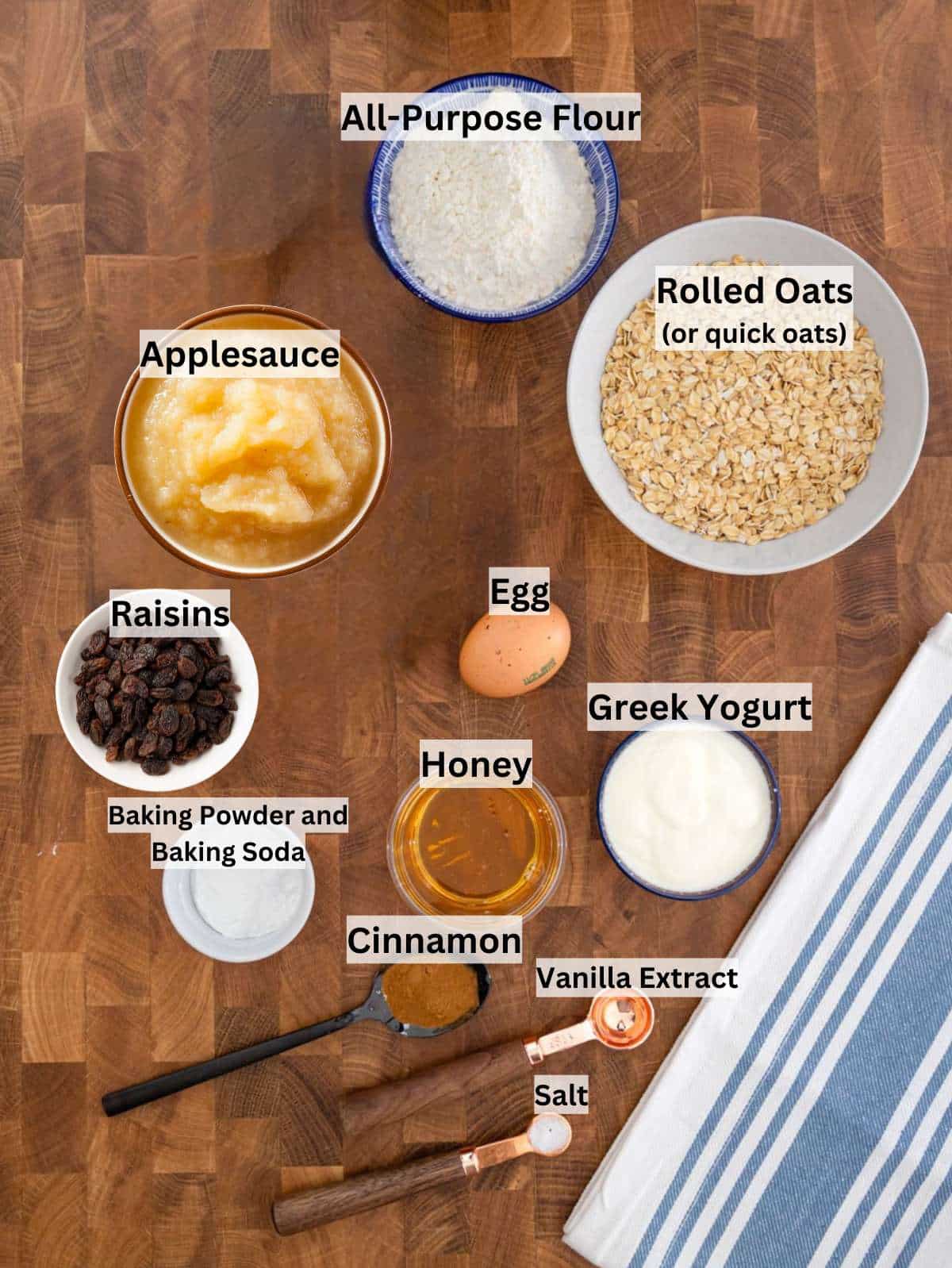 Ingredients for apple sauce muffins with oats yogurt honey raisins on a wooden table.
