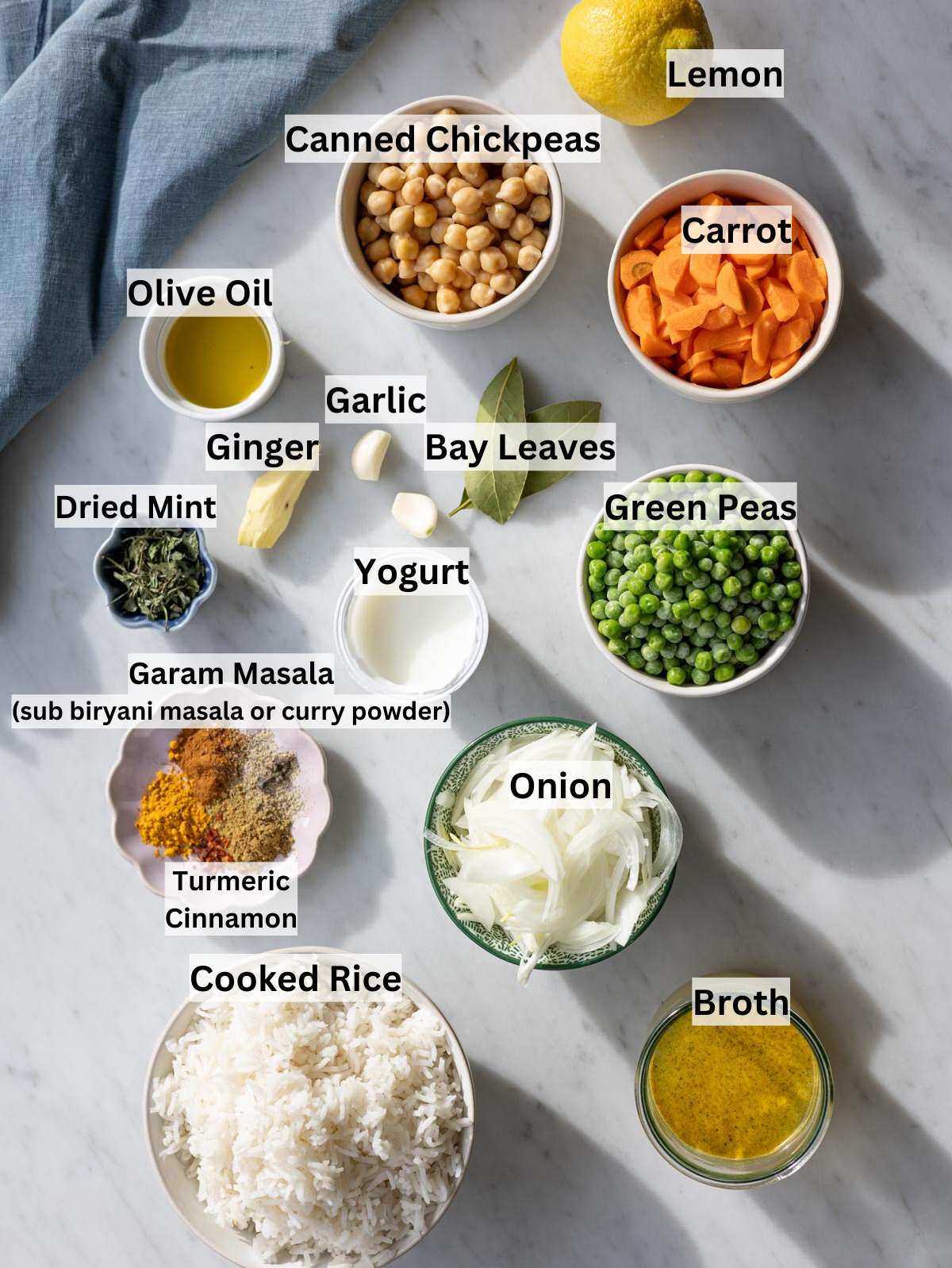Ingredients for vegetable biryani arranged on a kitchen counter with rice, vegetables, spices, and yogurt.