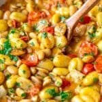 Mushroom gnocchi skillet on a rustic table with a wooden spoon, warm, creamy and inviting.