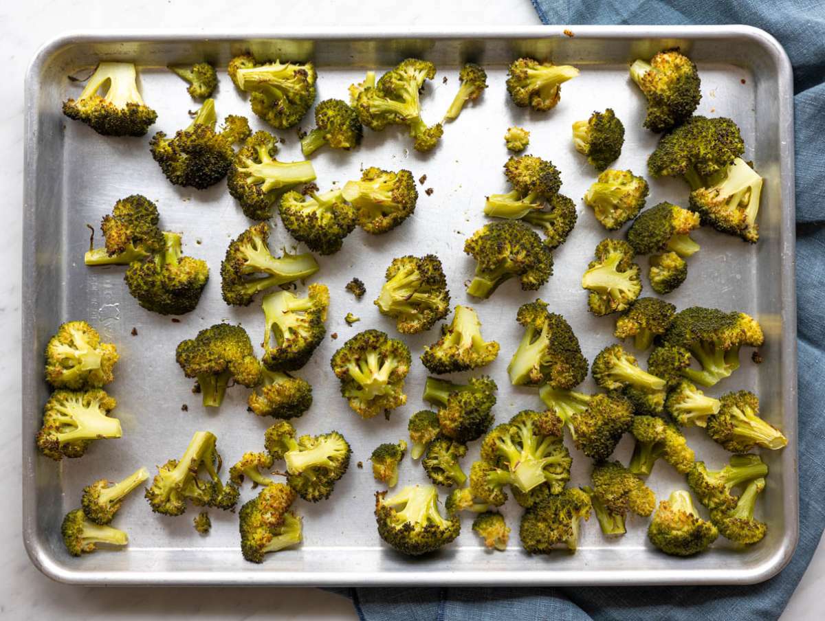 Step 1 Broccoli florets roasted with olive oil on a baking sheet.
