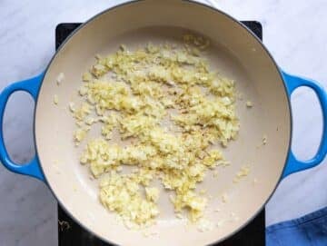 Step 1 Chopped onion sautéing in olive oil in a wide pot on the stove.