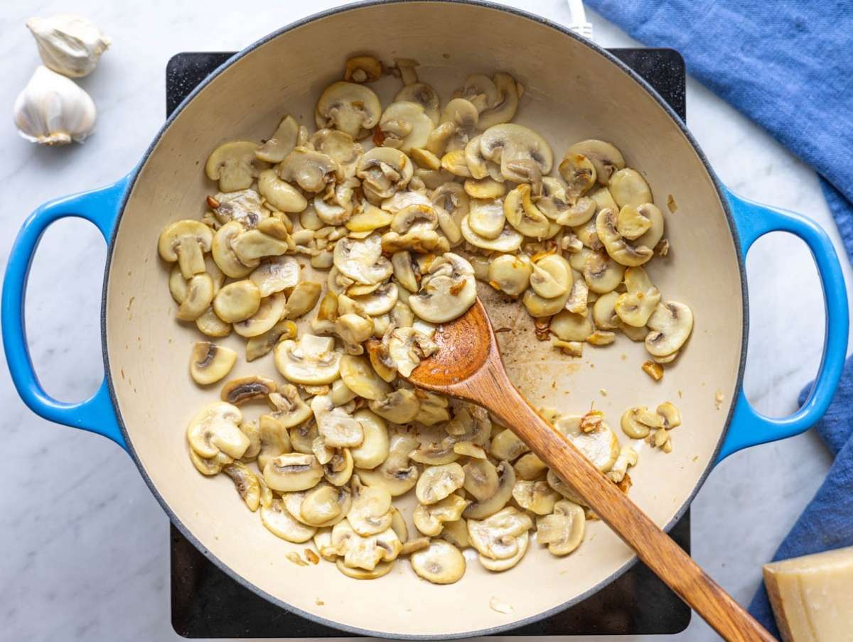 Step 1 Sliced mushrooms browning in a skillet with olive oil.