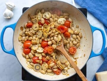Step 2 Cherry tomatoes and butter beans added to mushrooms, turning soft and saucy in the pan.