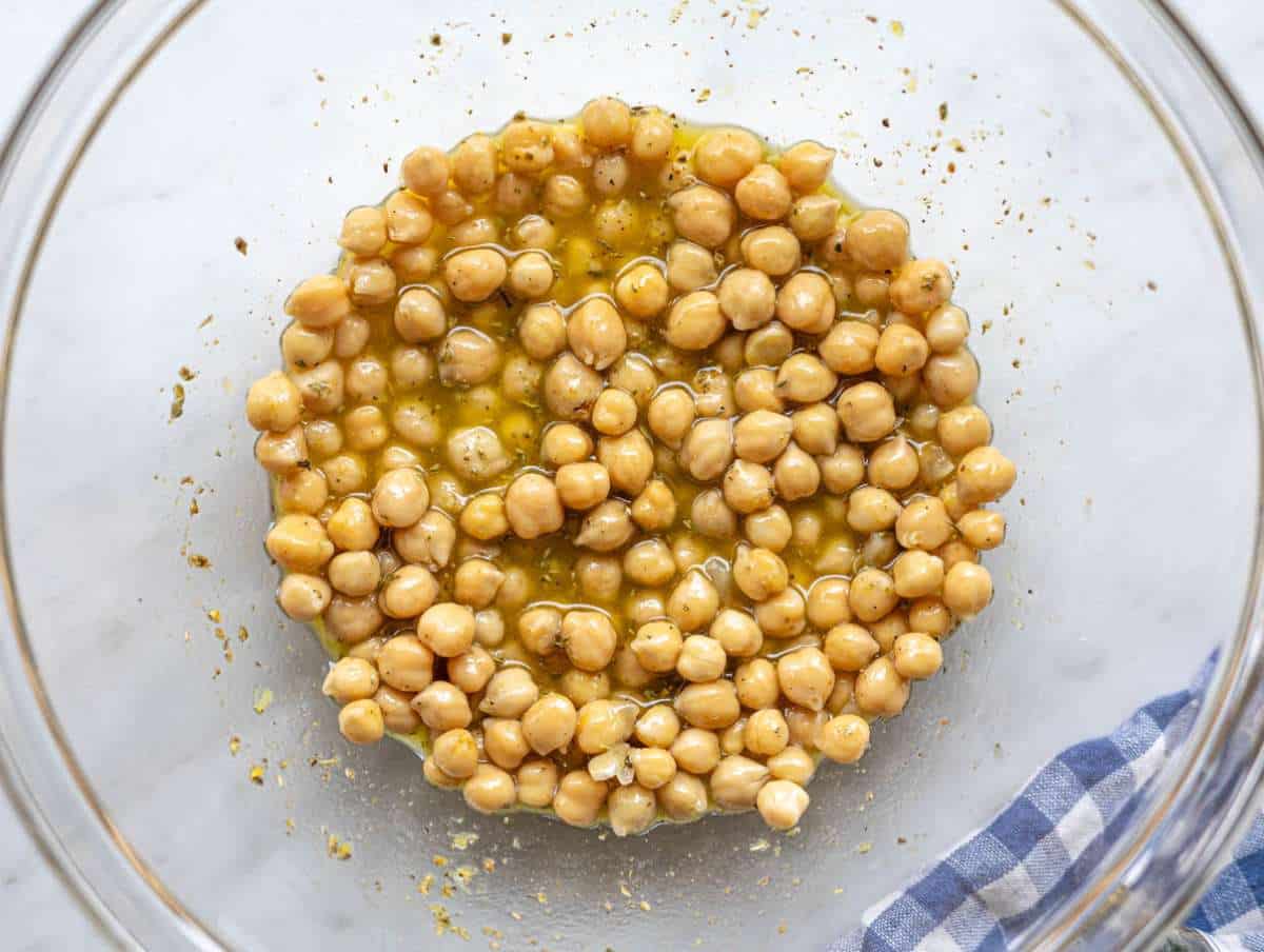 Step 2 Chickpeas tossed in lemon olive oil dressing inside a large mixing bowl.
