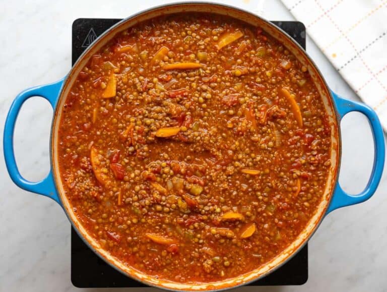 Step 2 Quinoa, lentils, tomatoes, and broth simmering together in a large pot.