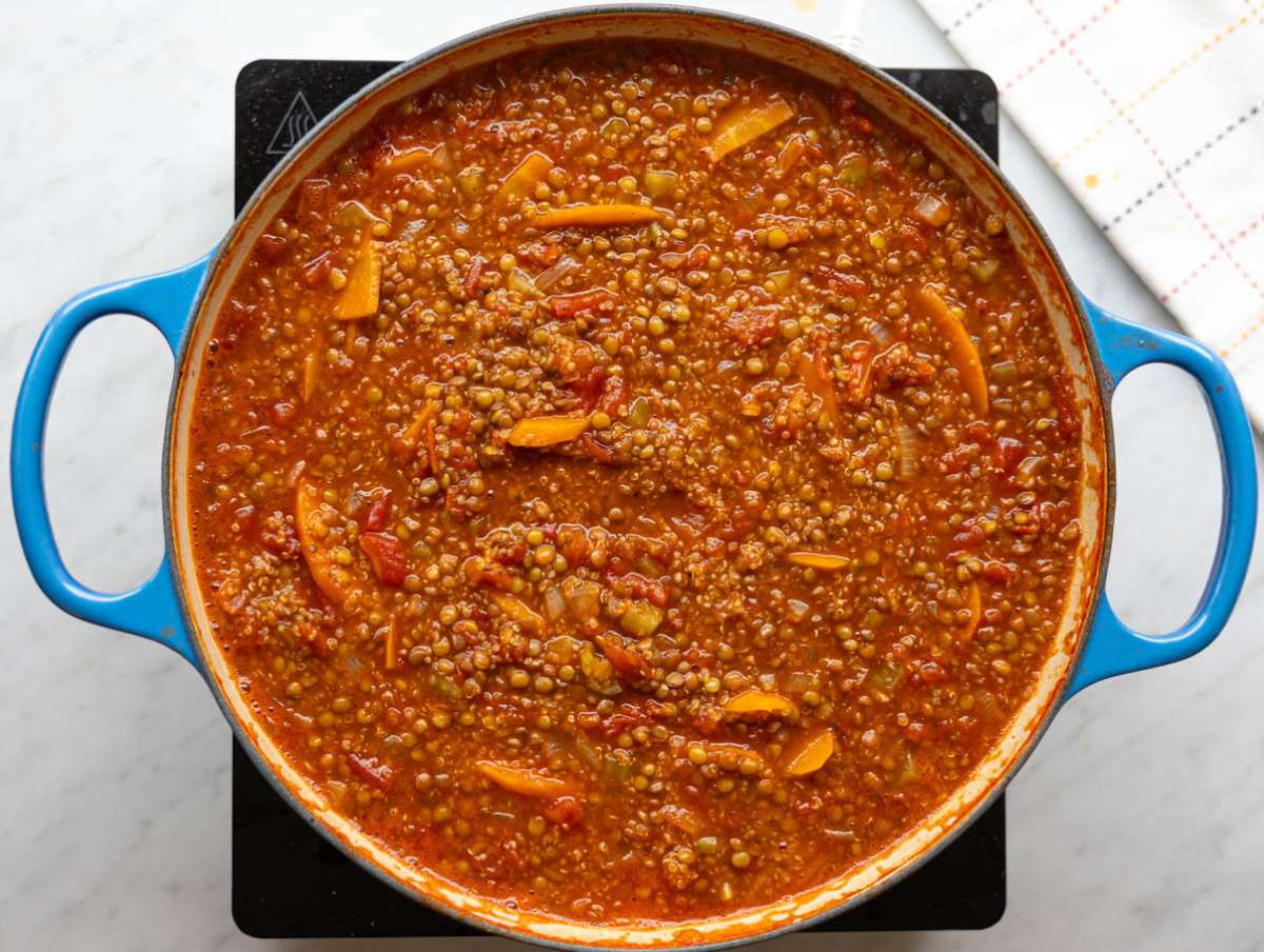 Step 2 Quinoa, lentils, tomatoes, and broth simmering together in a large pot.