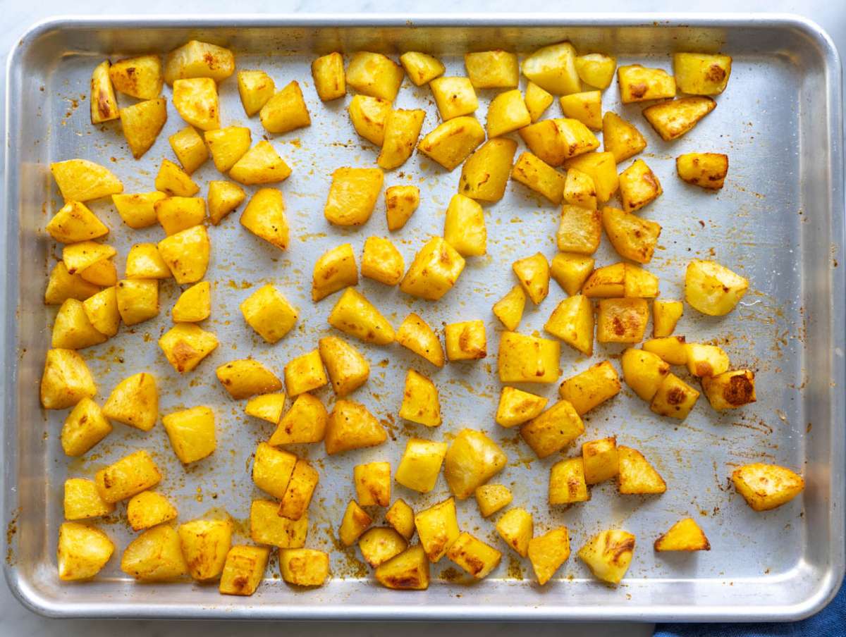 Step 2 Roasted potatoes with oil and spices on a baking sheet.