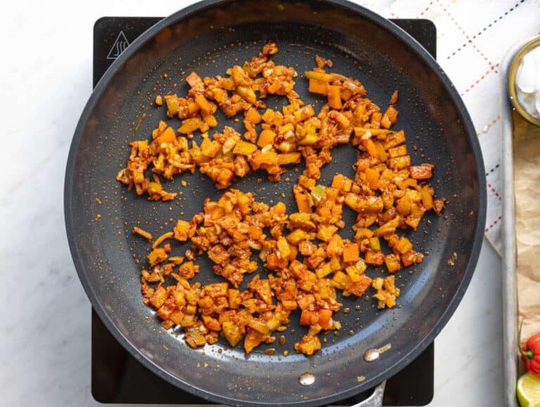 Step 2 Tomato paste and spices stirred into softened vegetables in a skillet.