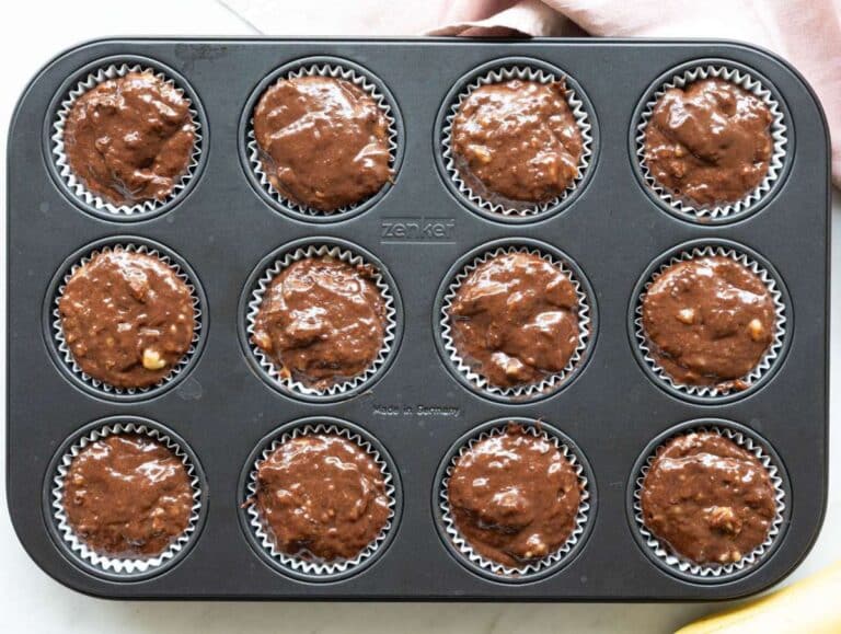 Step 3 Dark chocolate chunks folded into glossy muffin batter and spooned into paper liners.