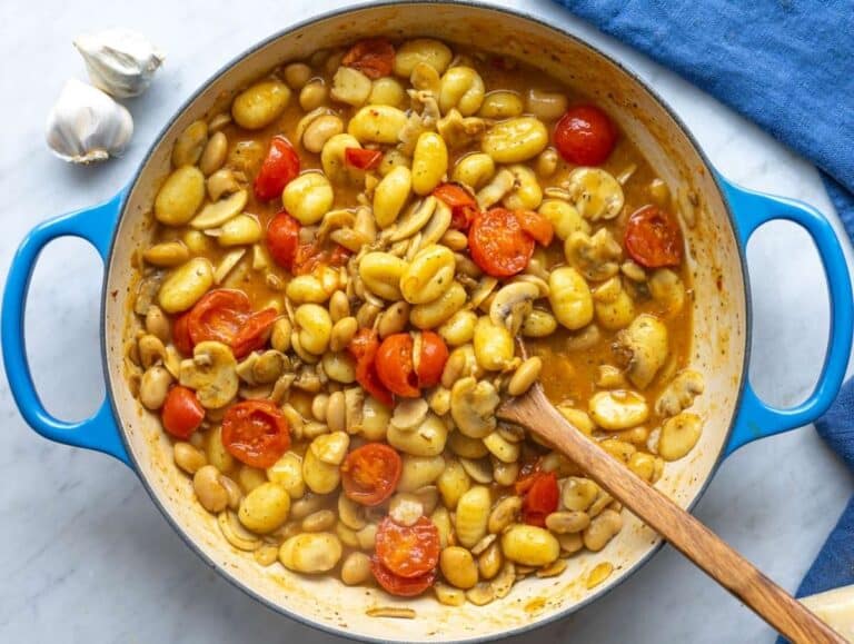 Step 3 Gnocchi simmering in vegetable broth with mushrooms and tomatoes, cooking directly in the skillet.