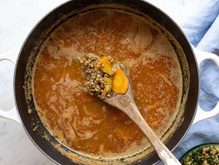 Step 3 Lentils simmering in broth in a large pot on the stove.
