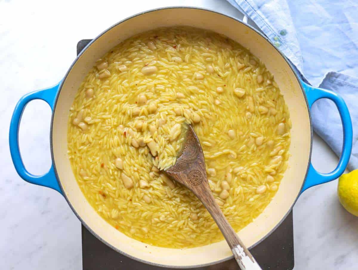 Step 3 Orzo and white beans simmering in broth until creamy in a wide skillet.