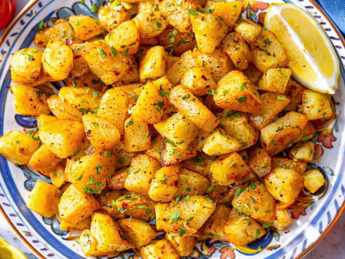 Step 4 Hot roasted potatoes tossed with garlic oil lemon juice and cilantro and served on a platter.