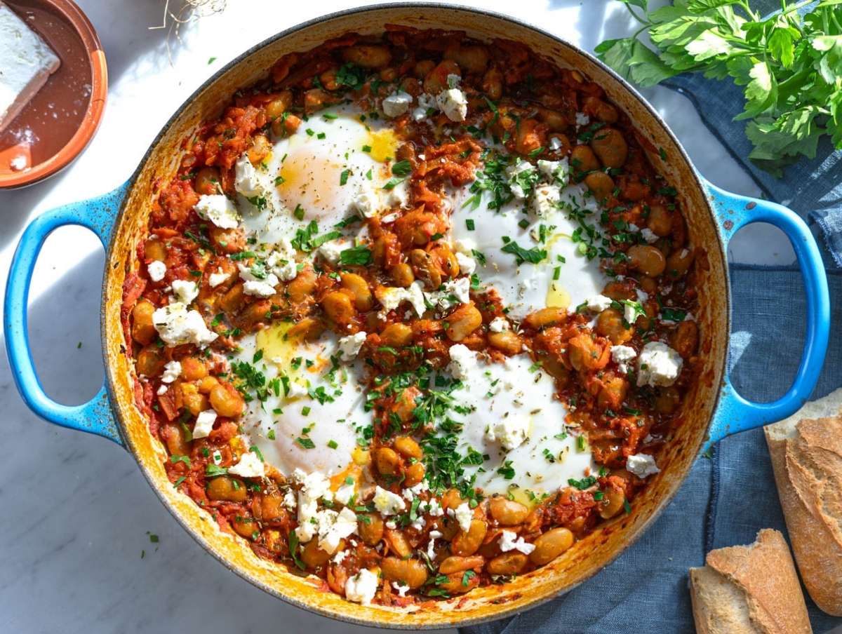 Variation of cozy baked beans with eggs feta and bread ready for dipping.