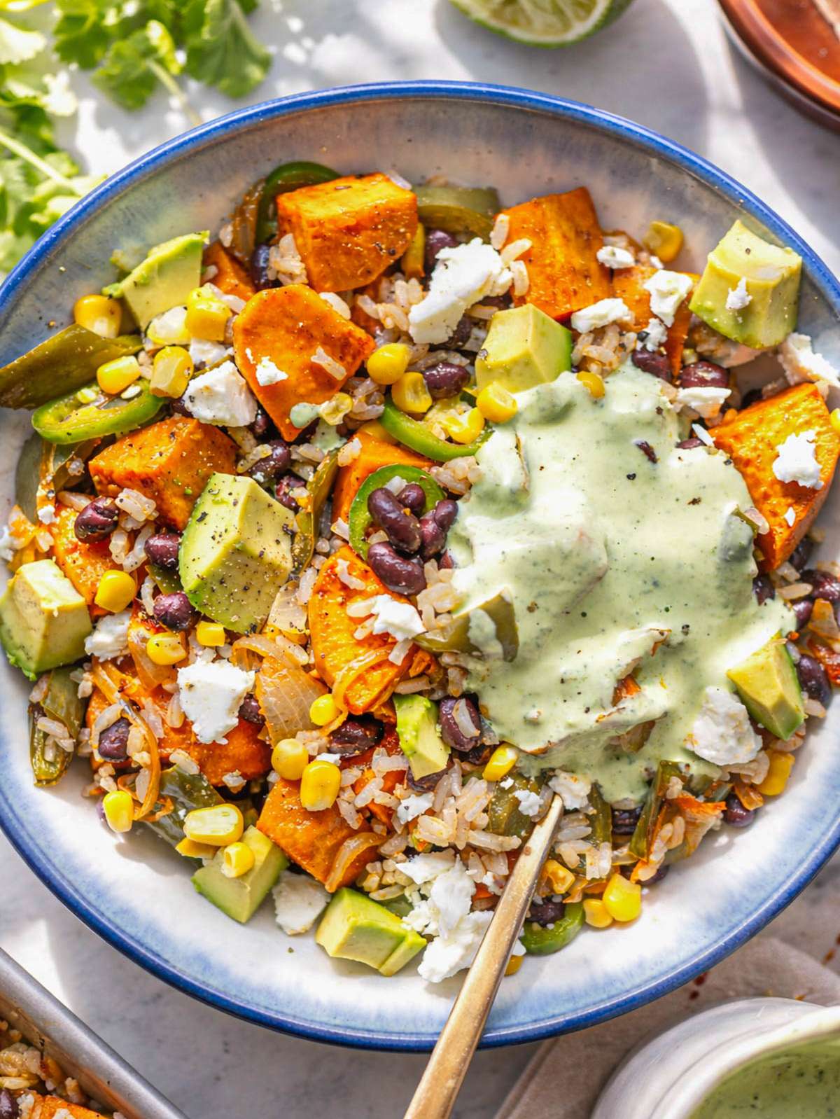 Black bean and rice bowl topped with avocado, feta, and yogurt sauce.