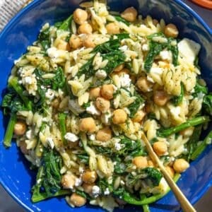 Bowl filled with spinach orzo, lemon zest, and scattered feta.