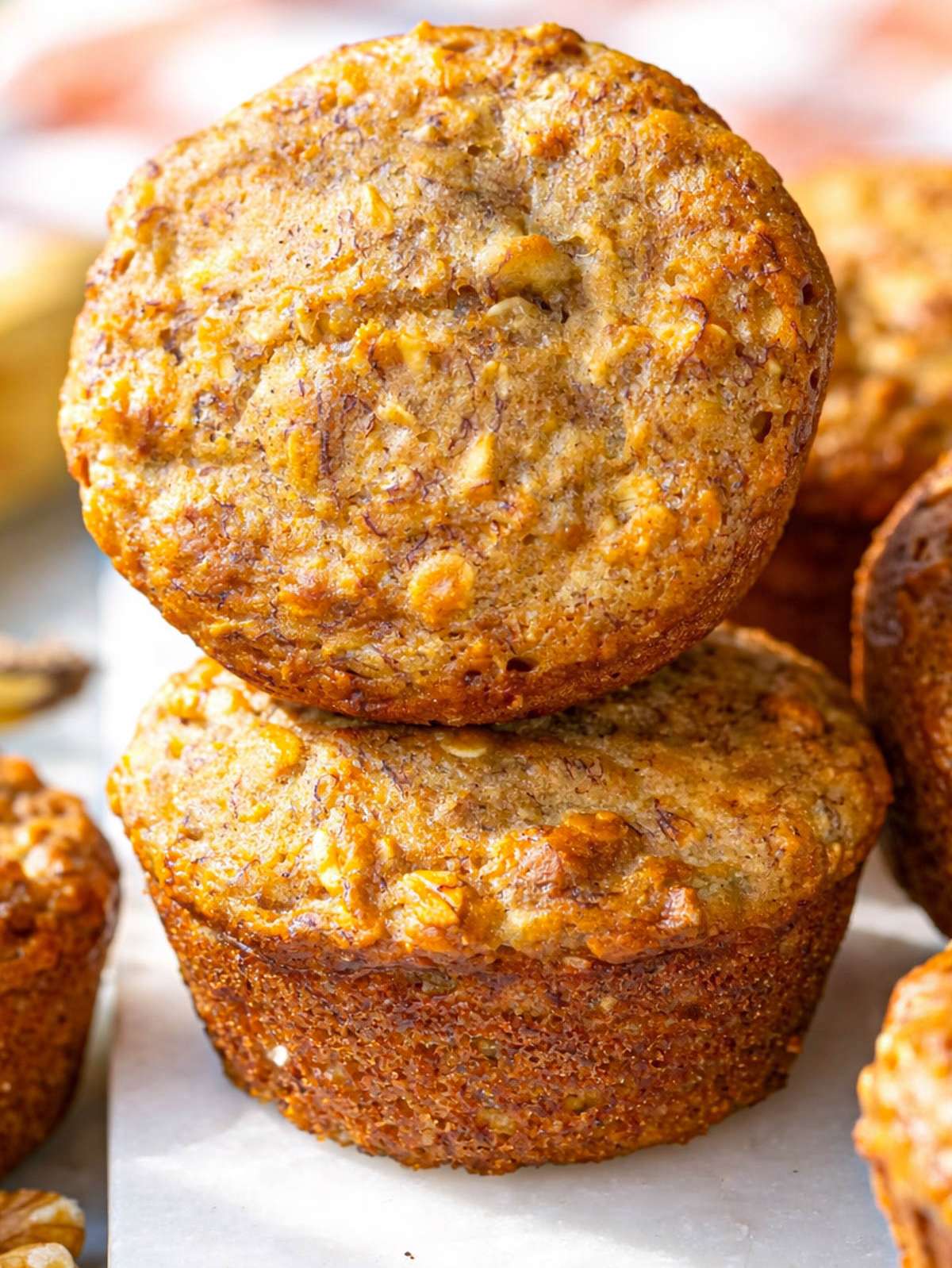 Close up of healthy banana nut muffins with golden tops and visible oats and nuts.
