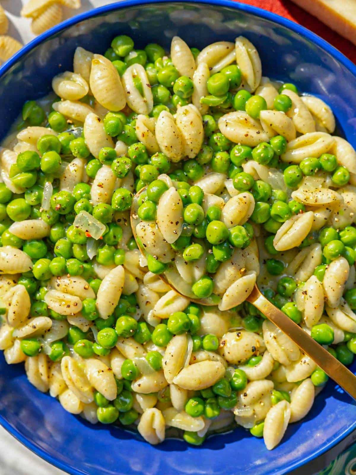 Close up of pasta and peas showing glossy sauce peas and tender pasta.