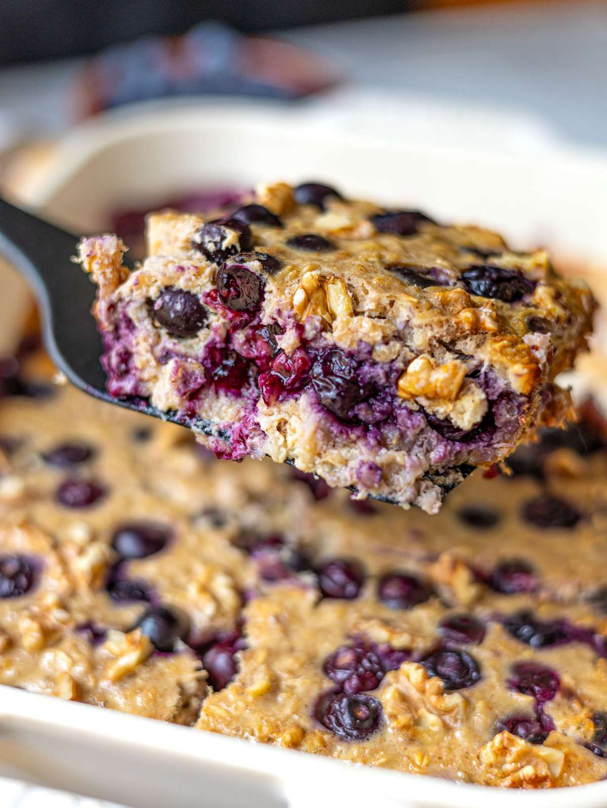 Close up of soft blueberry baked oatmeal showing creamy texture and juicy berries.