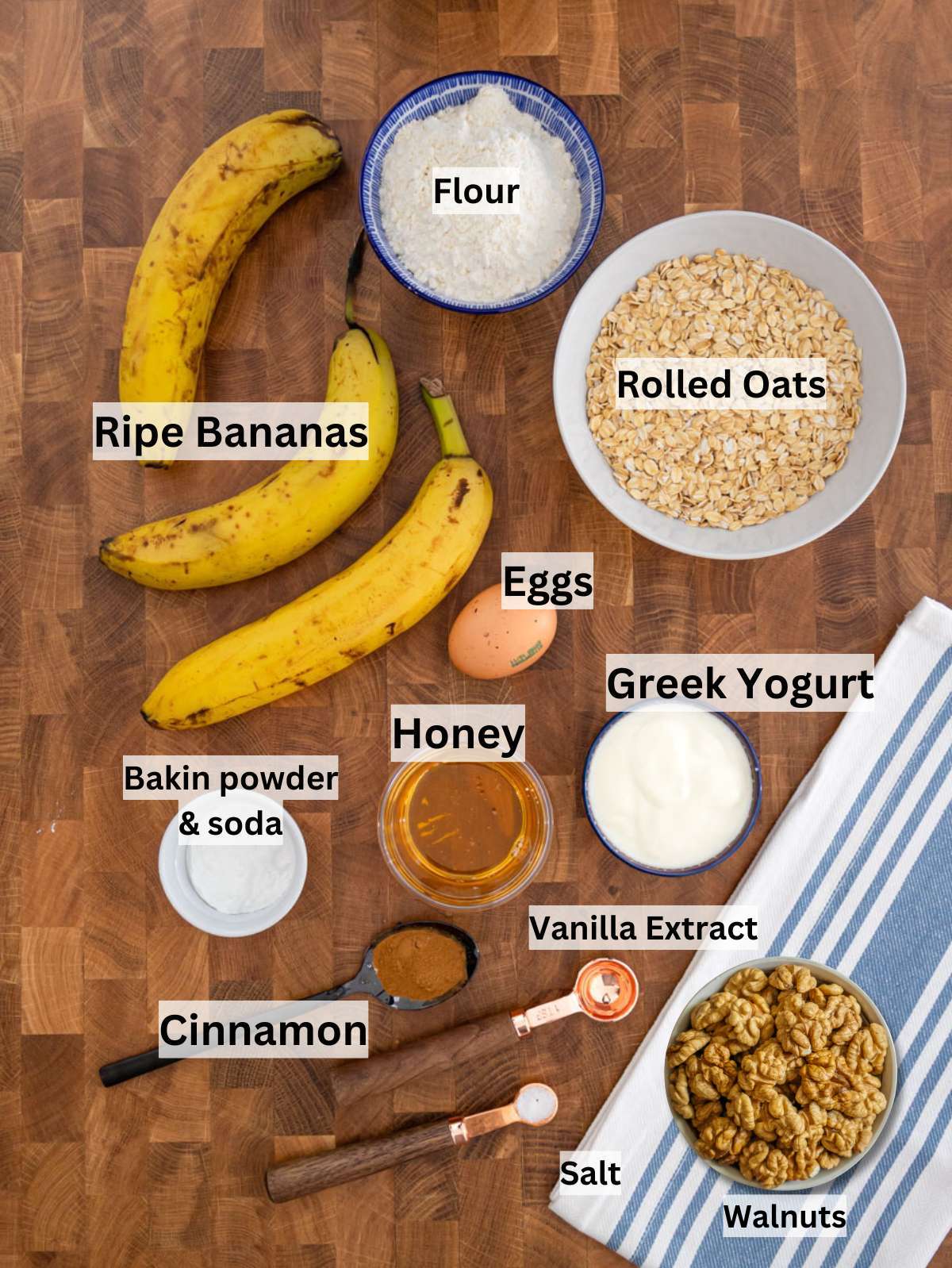 Ingredients for banana nut muffins arranged on counter with ripe bananas oats yogurt honey and walnuts.