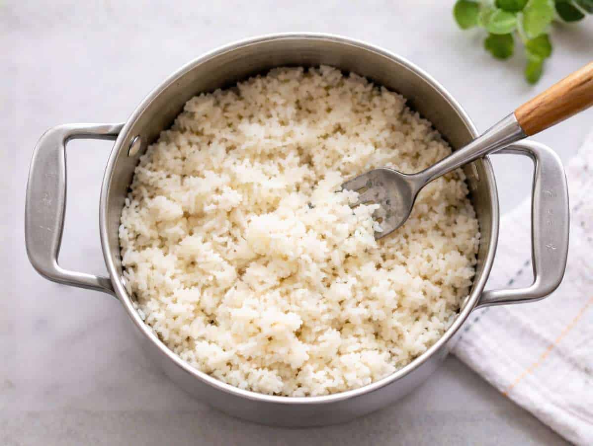 Step 1 Cooked rice in a pot fluffed up with a fork.