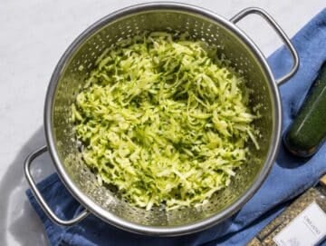Step 1 Freshly grated zucchini tossed with salt in metal colander.