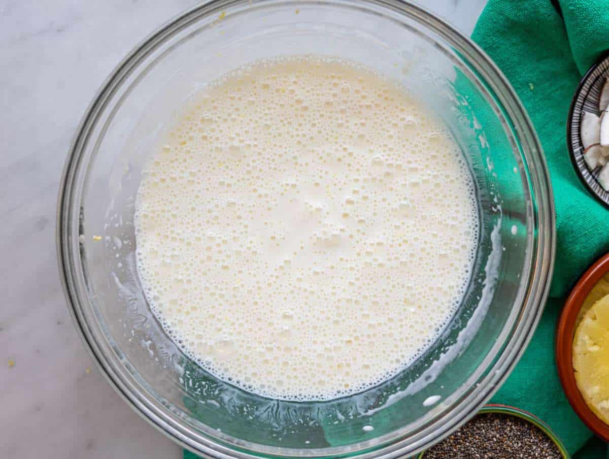 Step 1 Whisking Greek yogurt, milk, and pineapple juice in mixing bowl.