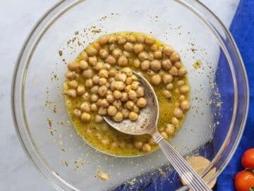 Step 2 Chickpeas coated in lemon dressing resting in a mixing bowl.