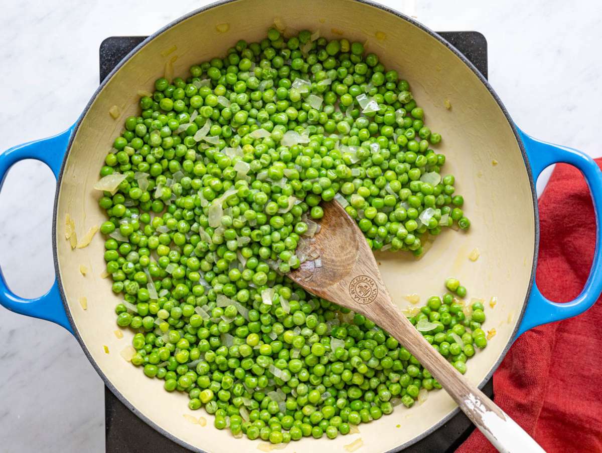 Step 2 Frozen peas added to softened onion in the pan.
