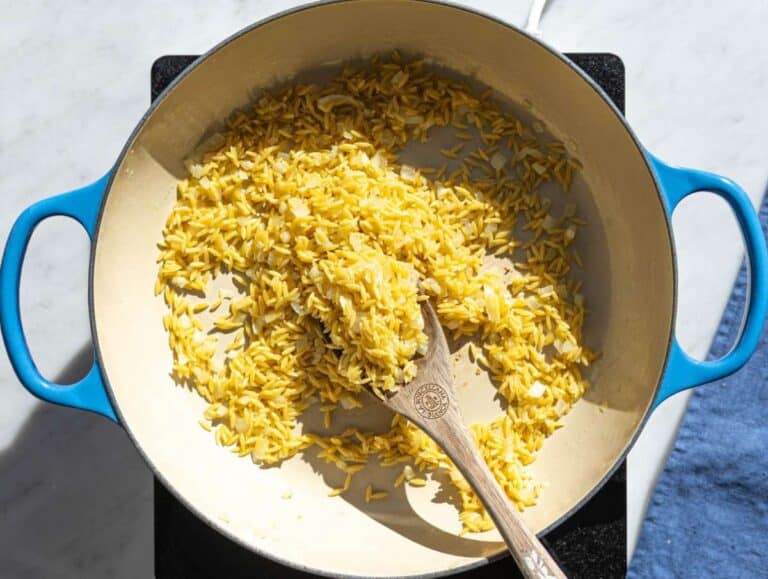 Step 2 Orzo toasting in skillet with onions and garlic.