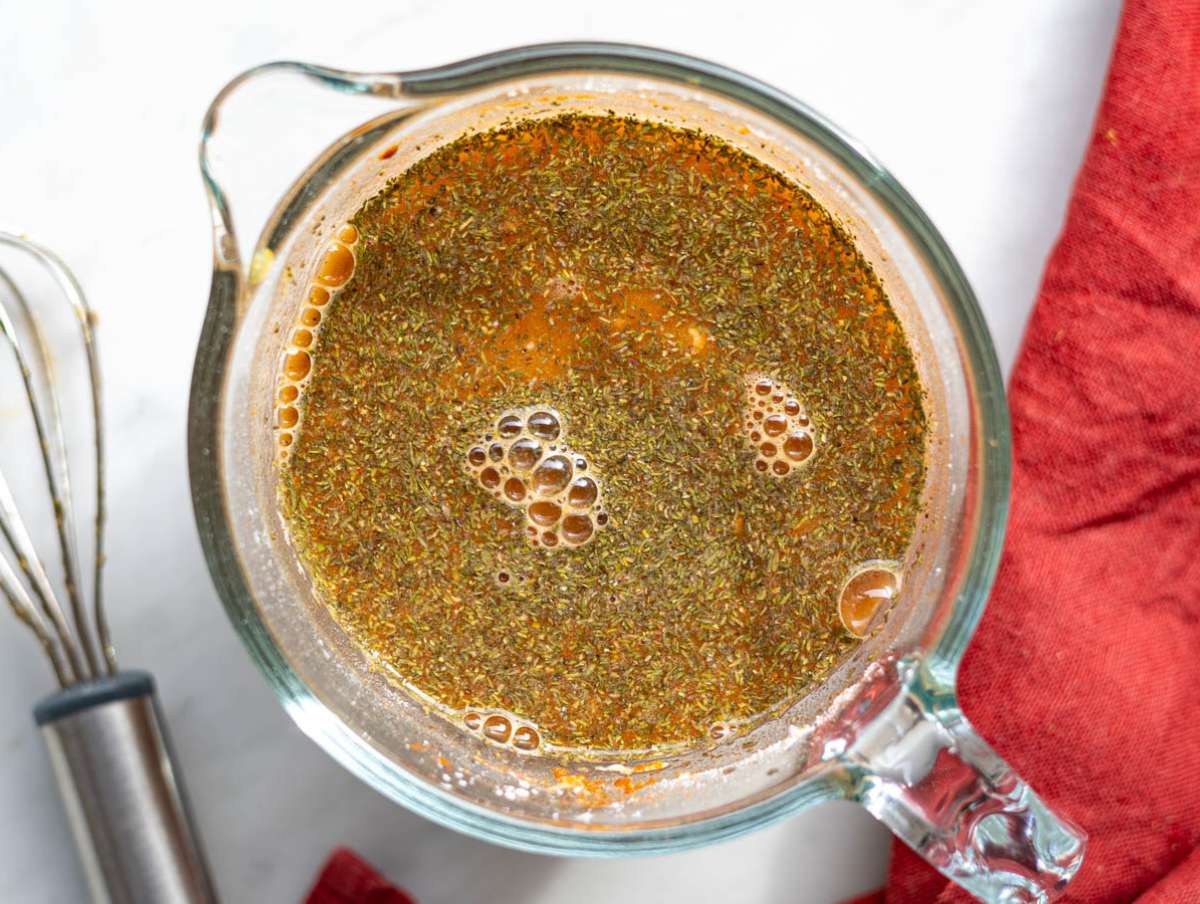 Step 3 Broth and flour mixture being whisked in glass measuring jug.