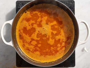 Step 3 Lentils tomatoes and broth simmering together in red soup.