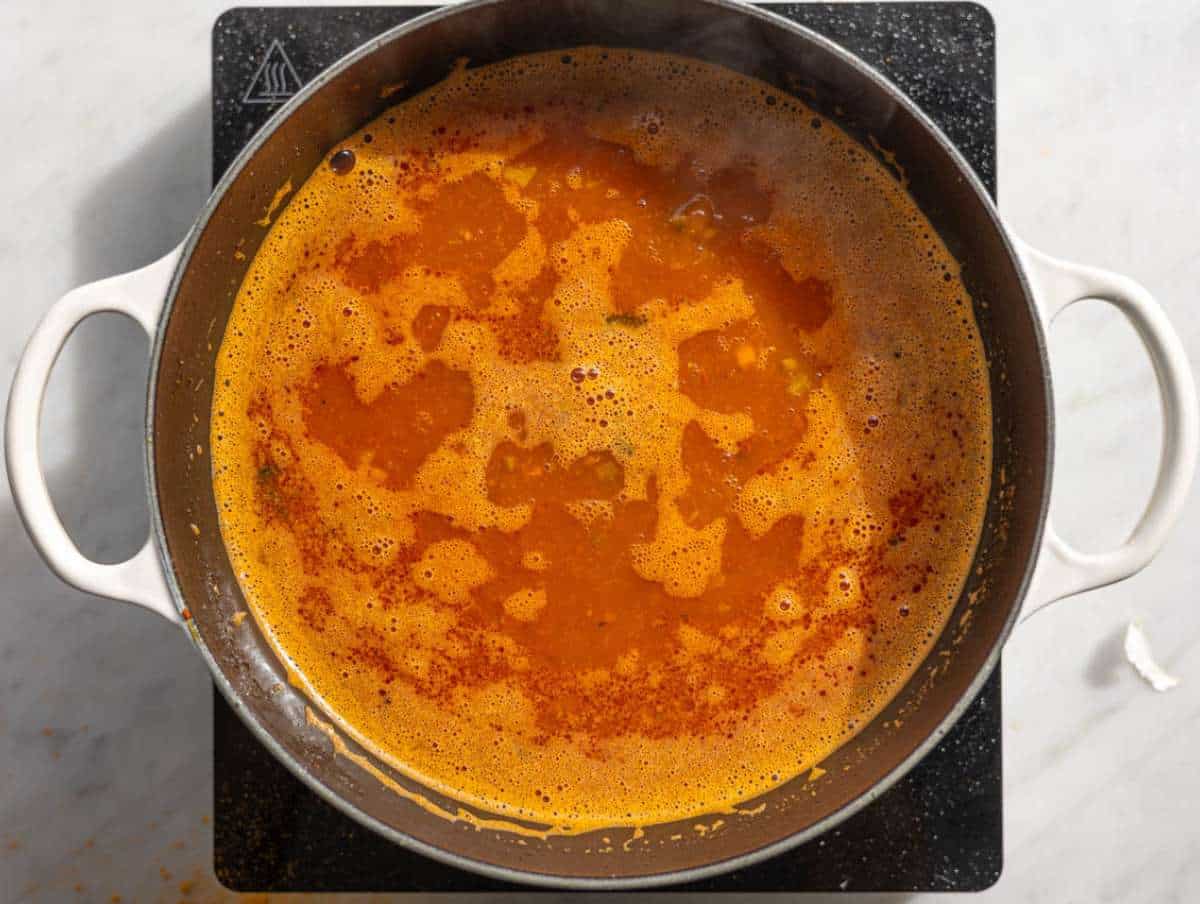 Step 3 Lentils tomatoes and broth simmering together in red soup.