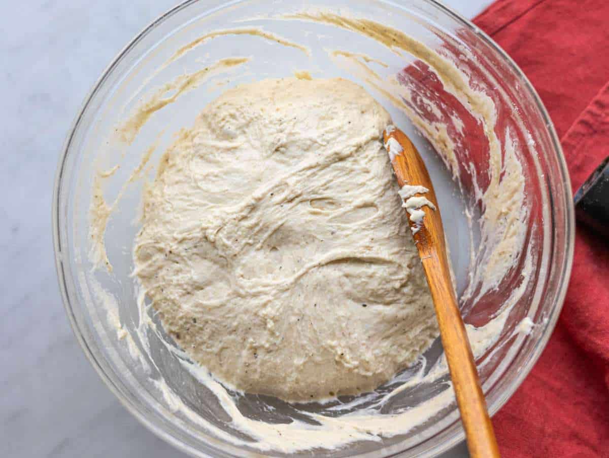 Step 4 Folding soft focaccia dough over itself with a spoon.