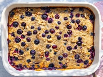 Step 5 Blueberry baked oats with Greek yogurt cooling down on a sun-lit marble table.