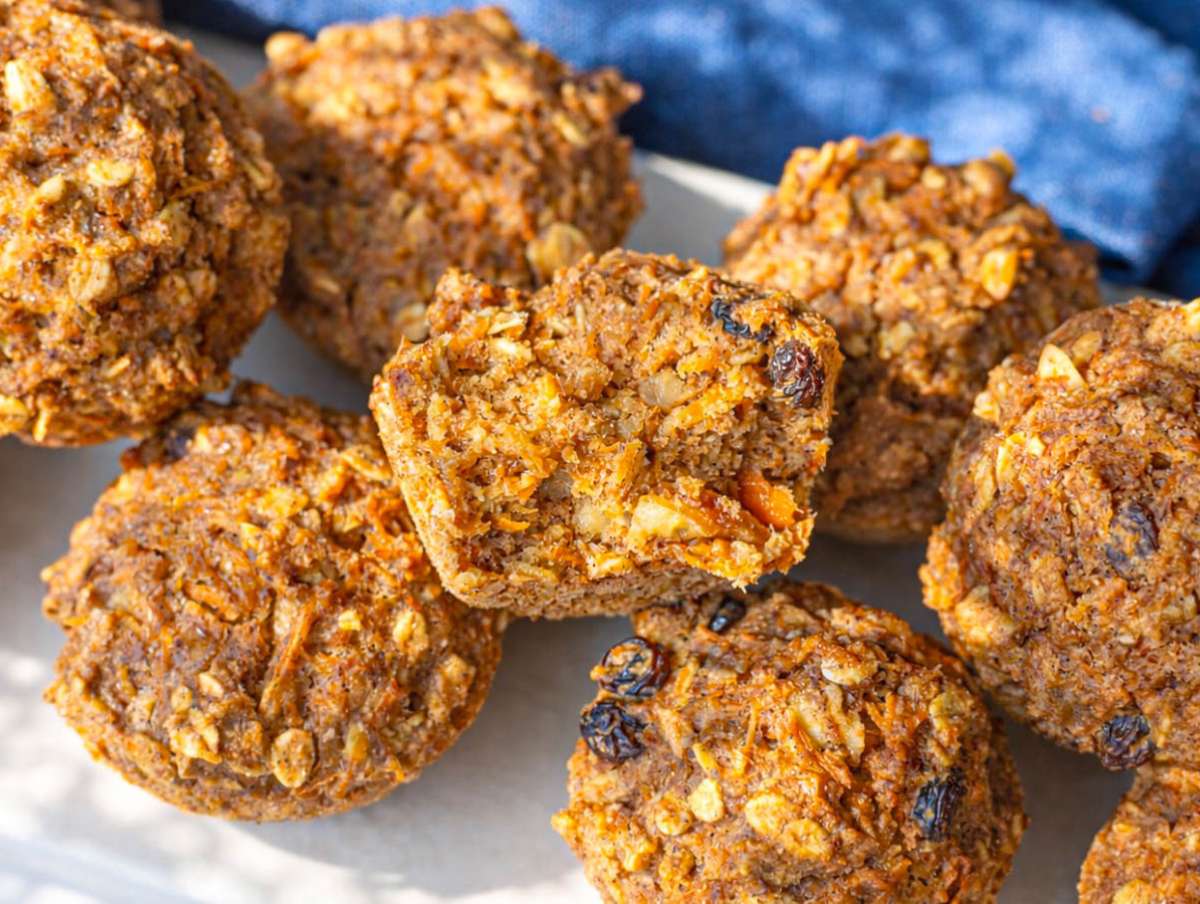 Step 5 Morning glory muffins cooling on marble table with one cut open showing soft center.